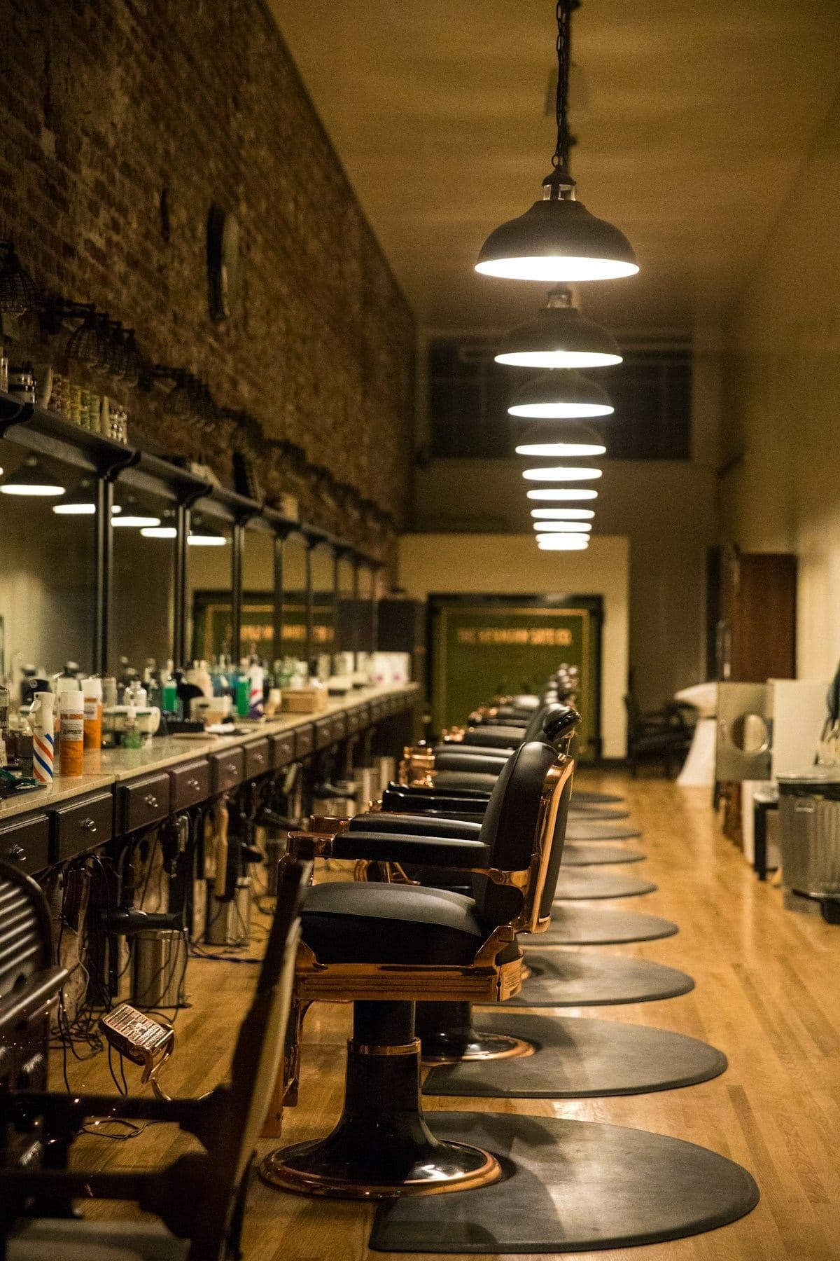 A row of brass-trimmed barber chairs down the length of the shop