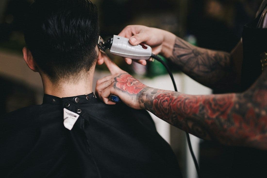 A barber tapering the nape with clippers